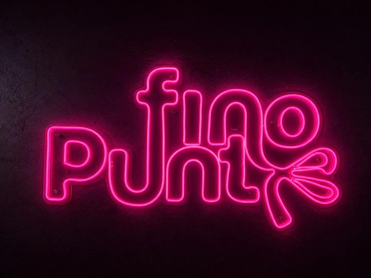 Aviso luminoso rosa de Puntofino sobre muro oscuro